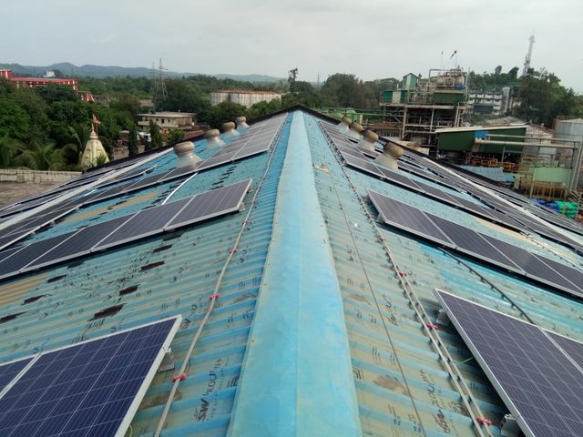 Solar panels installed along a factory roof ridge